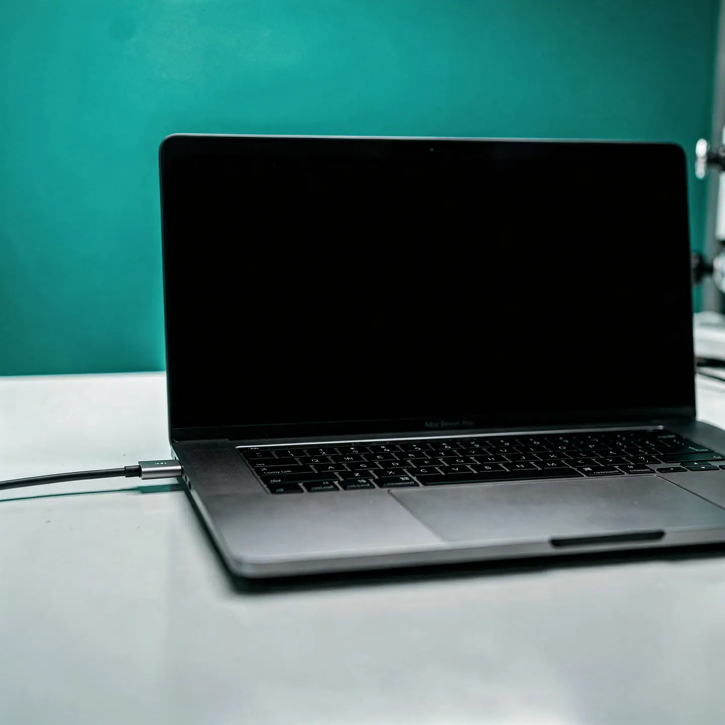 MacBook Pro avec écran noir posé sur un bureau, nécessitant un diagnostic gratuit