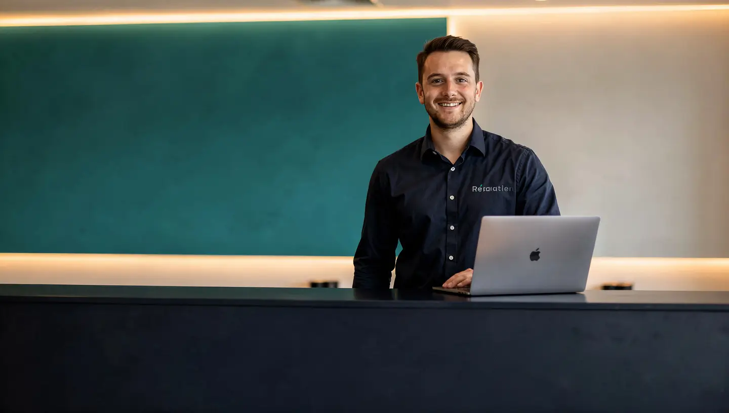 Accueil de l'atelier Réparation MAC à Bruxelles avec technicien prêt à recevoir les clients